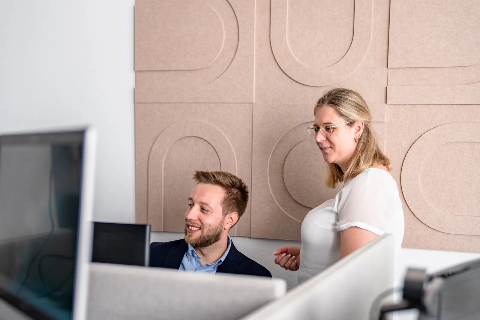 Kollege und Kollegin besprechen sich am Arbeitsplatz im Cogitaris-Büro in Mainz